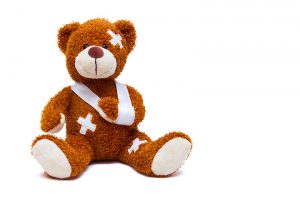 Injured teddy bear on white background